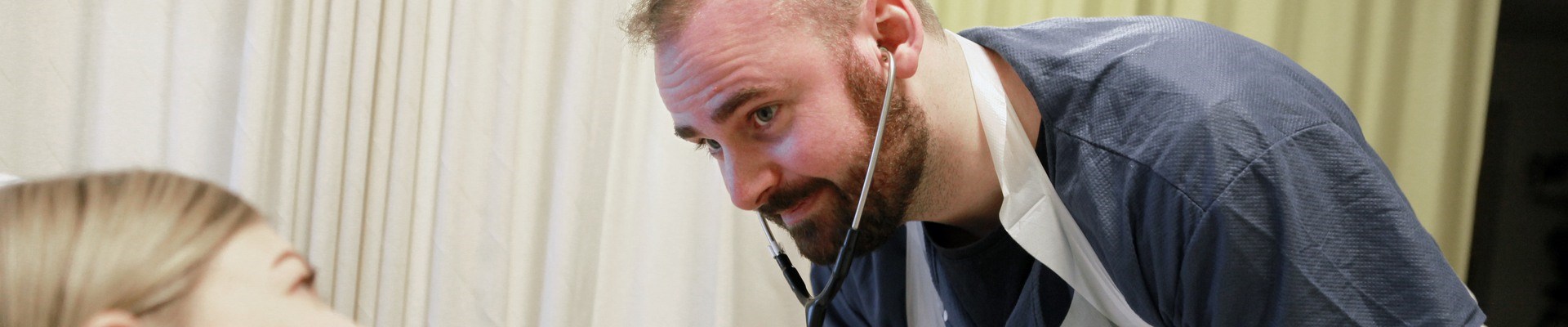 En sjuksköterskestudent lyssnar i ett stetoskop