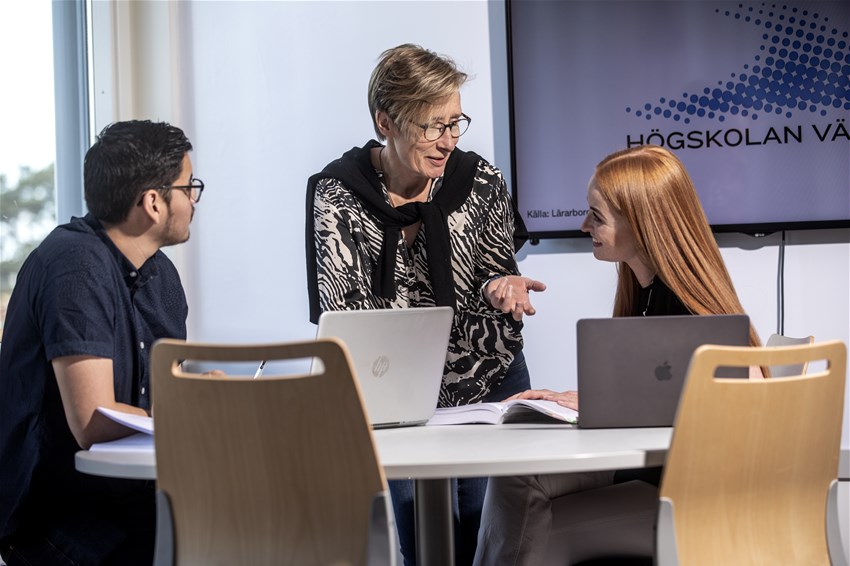 Studenter och lärare sitter tillsammans runt ett bord