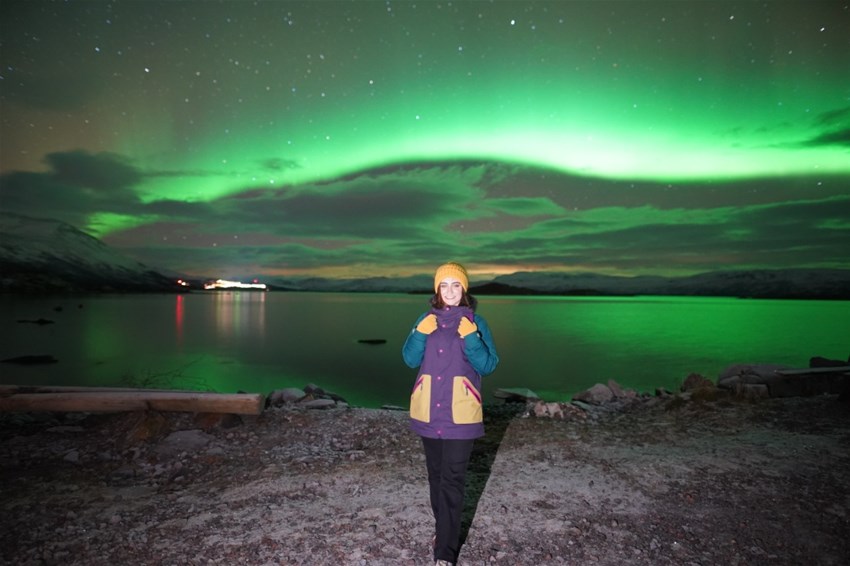 Woman in the night with northen lights behind her