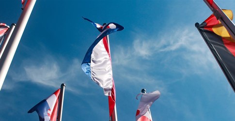 Flaggor flaggstänger mot blå himmel