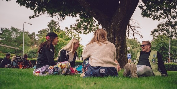 Studenter sitter vid gräsmatta