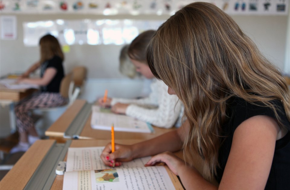 Barn som sitter i ett klassrum och skriver