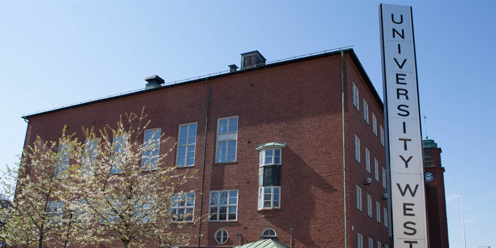 Exteriörbild på högskolans byggnader, samt träd och himmel. Foto