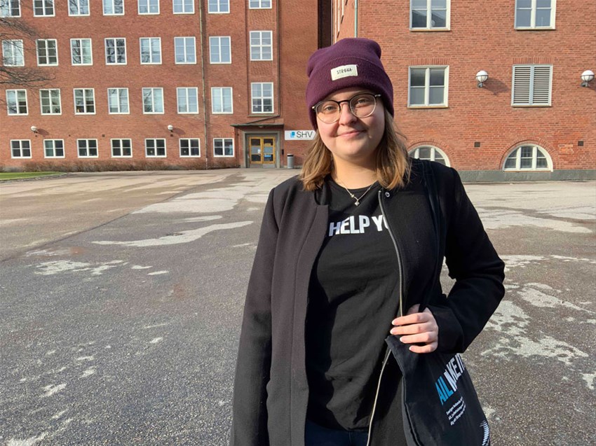 Student som står framför Studentkårens hus