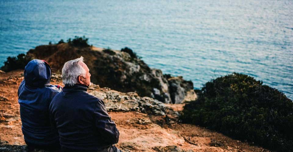 Older people sitting together in front of the sea Photo by katarzynagrabowska - Unsplash