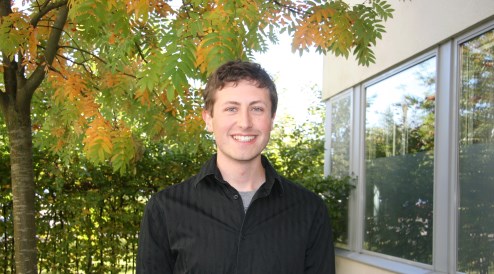 en person som står framför ett fönster och ett träd