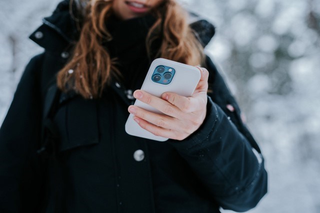 Tjej håller i smartphone, utomhus