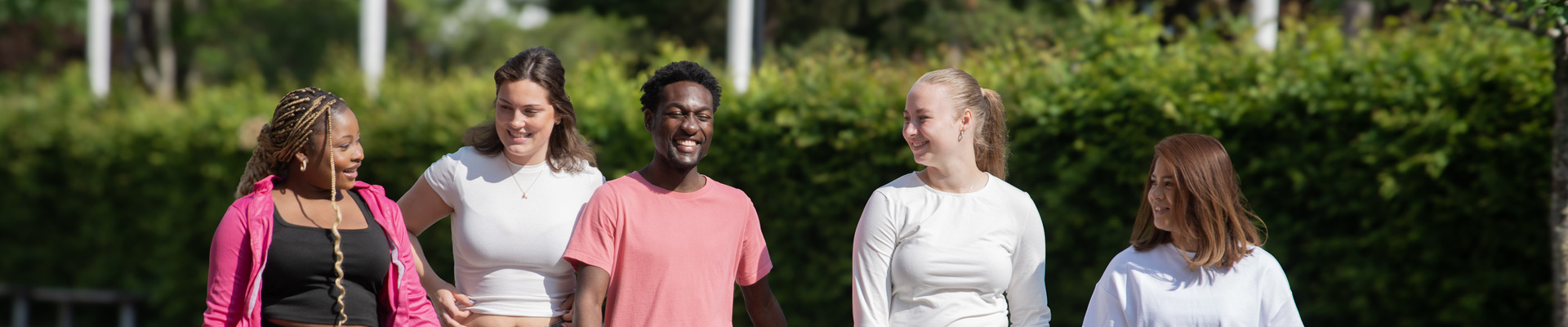 Studenter går tillsammans utomhus på campusområdet.