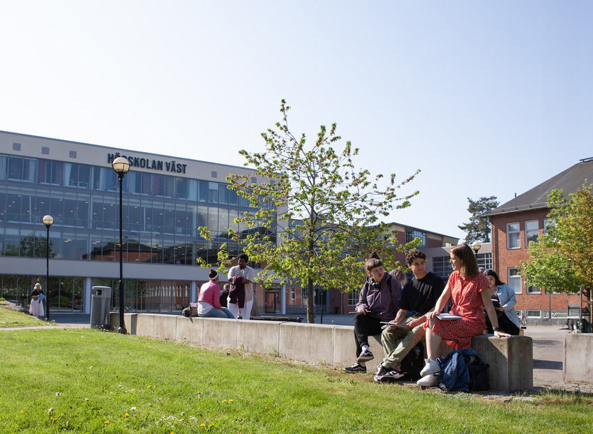 Studenter sitter tillsammans utanför Högskolan Västs campus.
