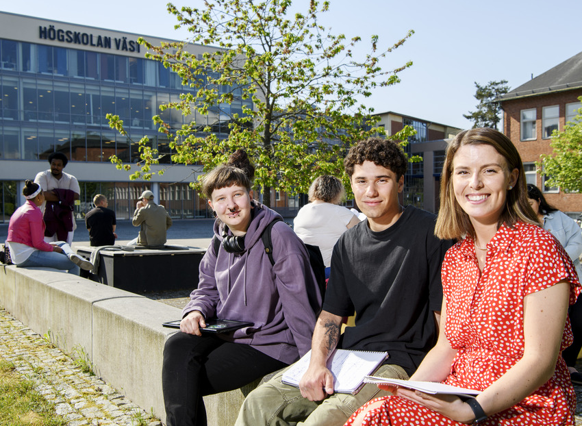 Studenter på Högskolan Väst sitter tillsammans utomhus utanför campus.