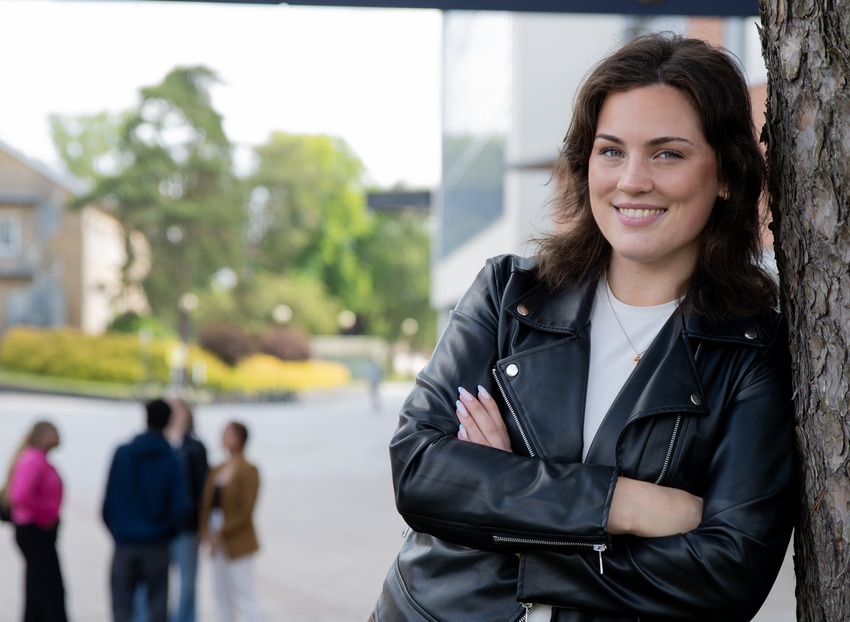 Student i förgrunden och flera studenter bakom.