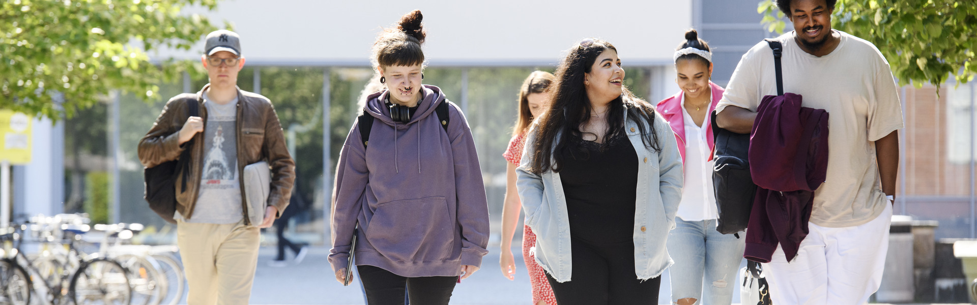 Studenter på Högskolan Väst går utomhus från campus.