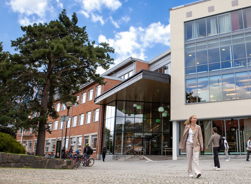 Studenter går utanför Högskolan Västs campus.