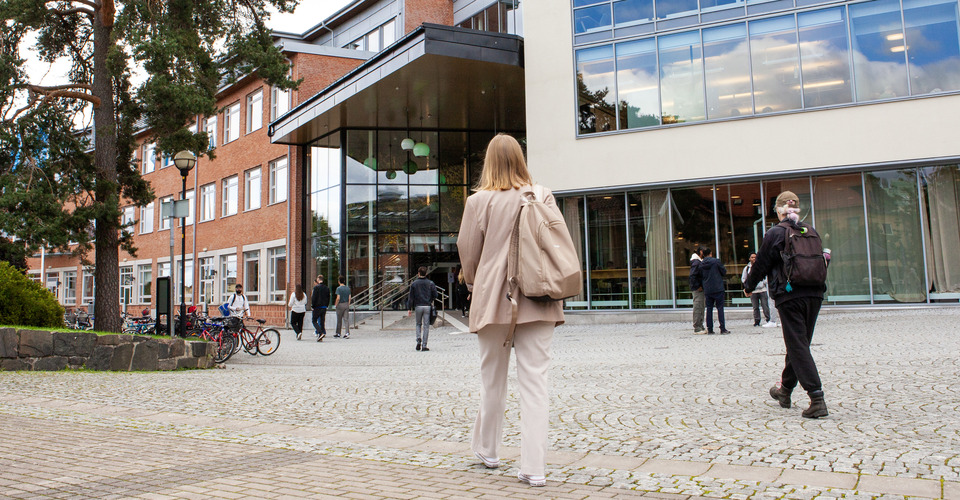 Student går mot Högskolan Västs campus.