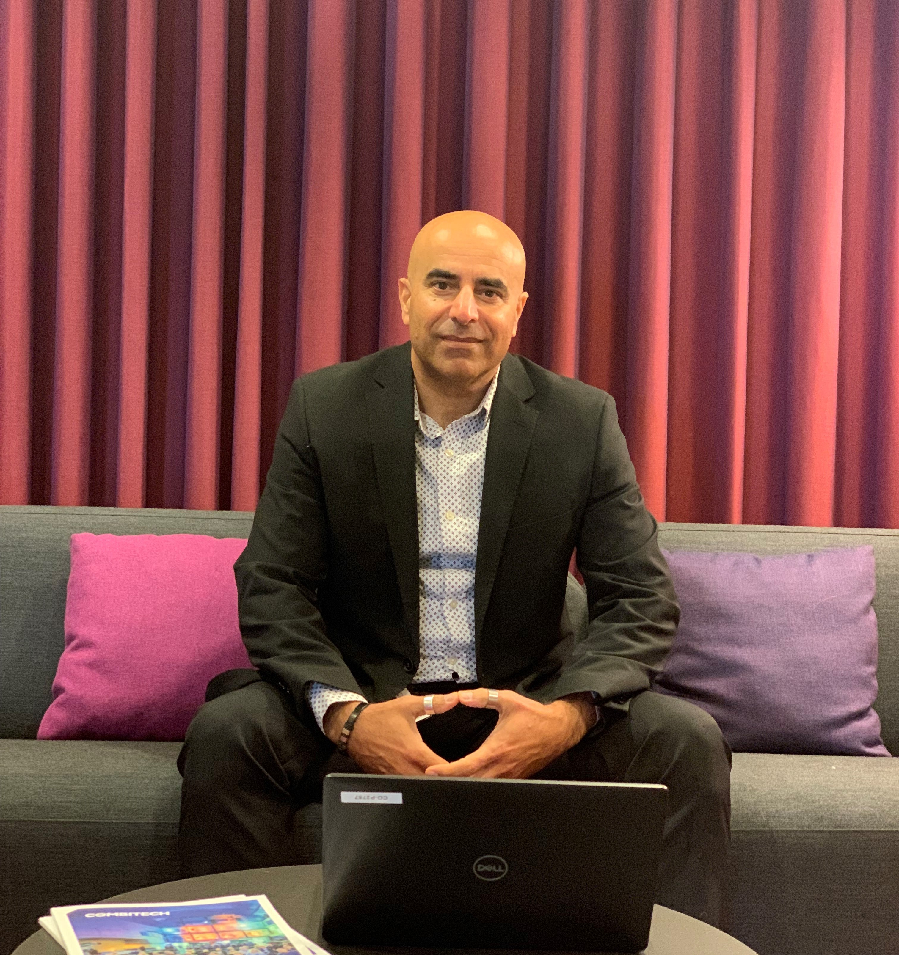 Man sitting in a suit, sitting on a couch.