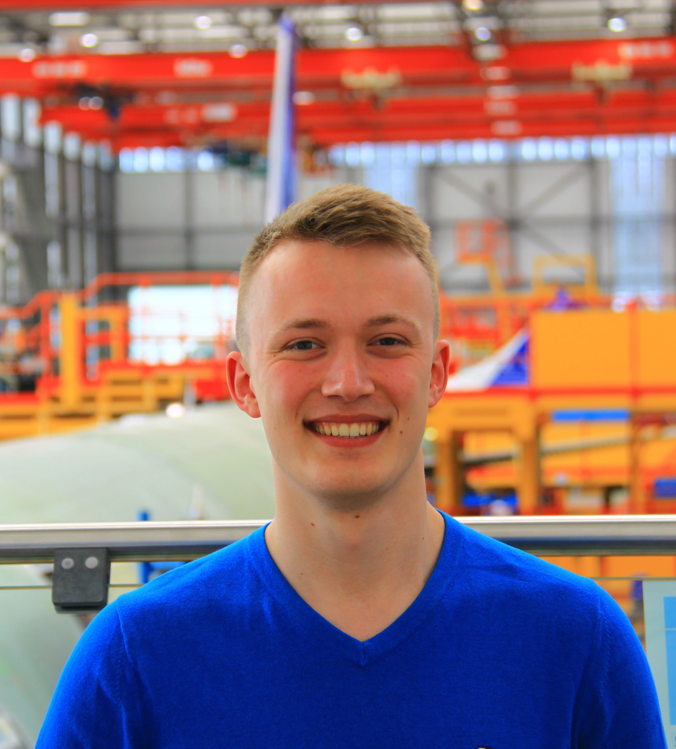 Young man stading infront of orange robots 