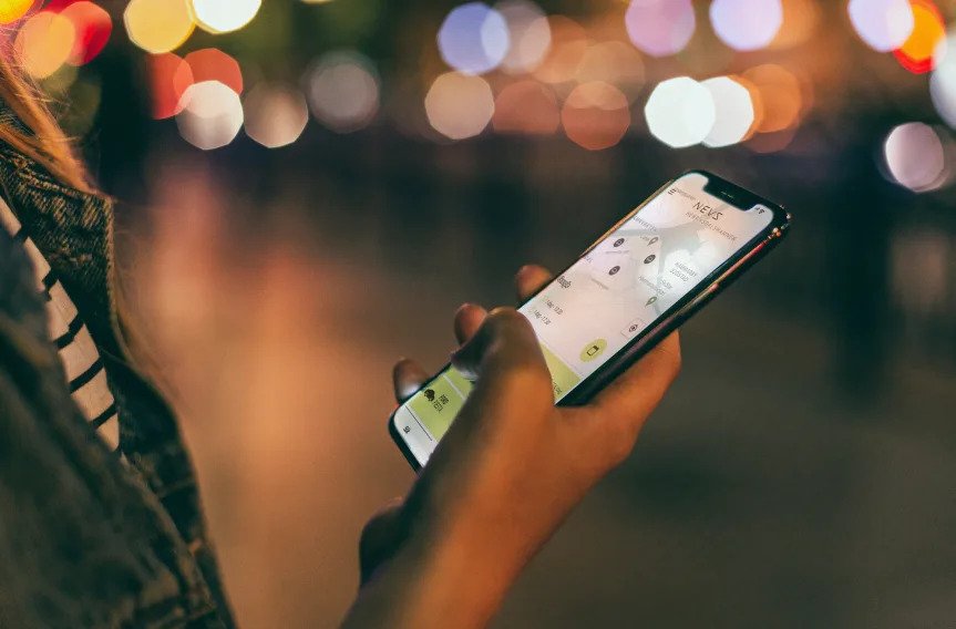 Kvinna som är inne på sin telefon och NEVS Share-appen