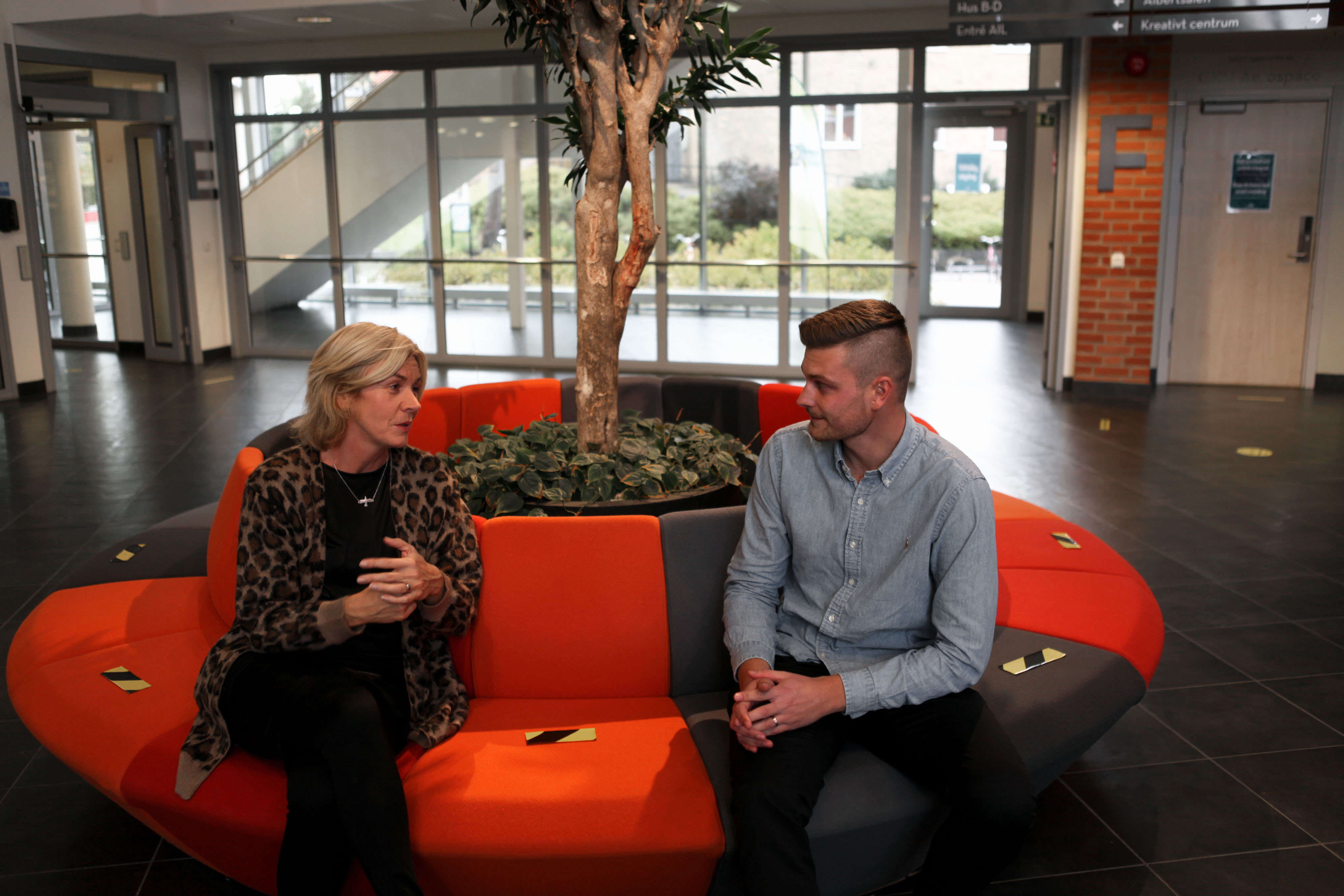Angelica Dahlman och Rasmus Nordgren i samtal i en soffa vid högskolans Servicecenter